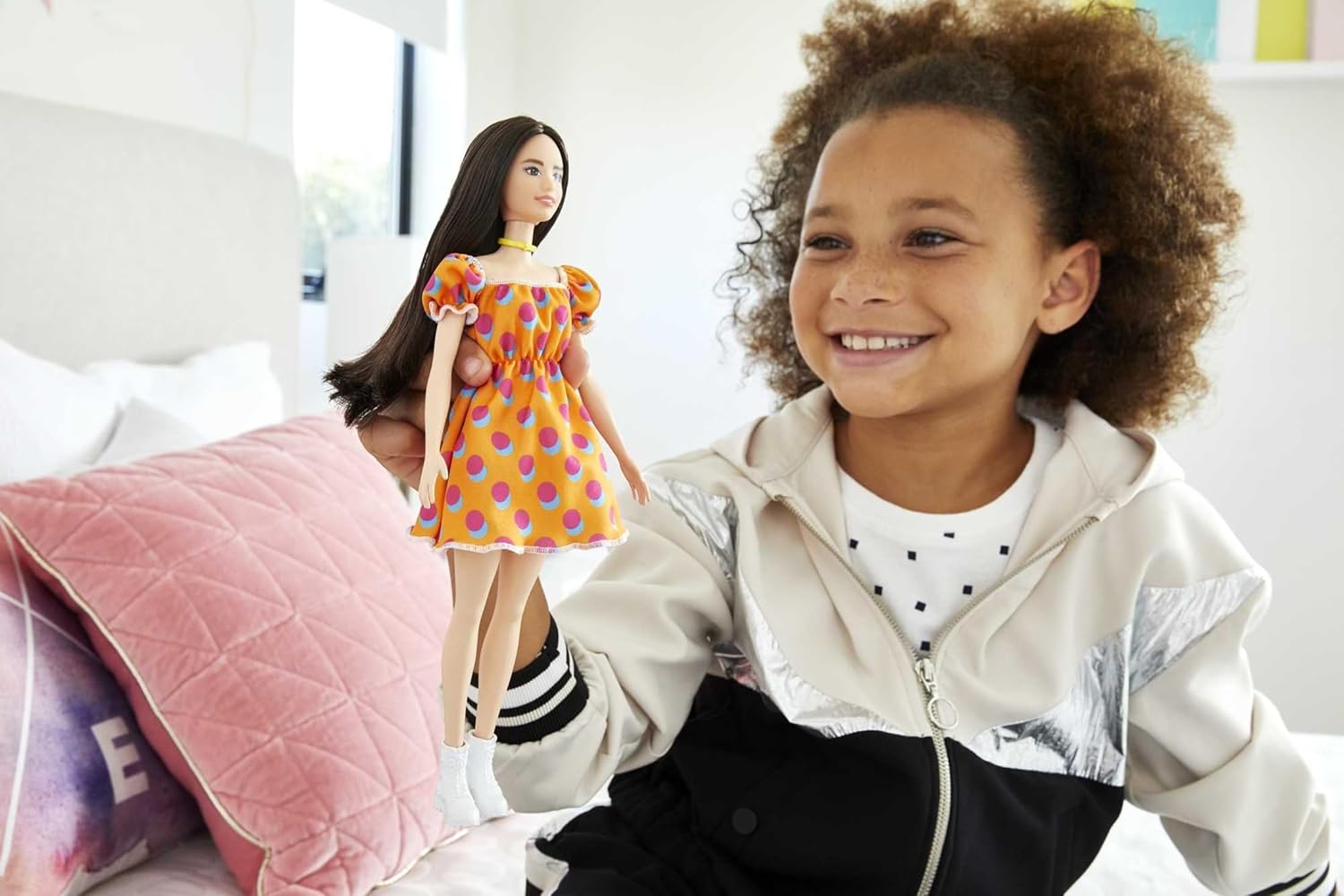 Barbie Fashionistas-Puppe mit langen brünetten Haaren, einem gemusterten orangefarbenen Kleid, weißen Schuhen und einem gelben Halsband